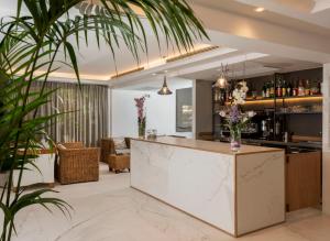 a bar in a living room with plants at Atlas Hotel in Riccione