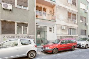 two cars parked in front of a building at Casablanca apartment in Belgrade