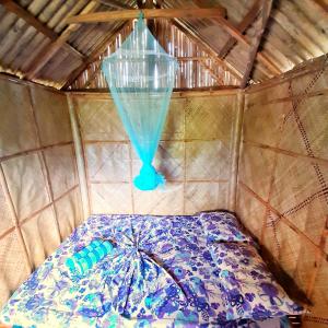 een kamer met een bed met een blauwe trechter bij Banana Grove El Nido in El Nido