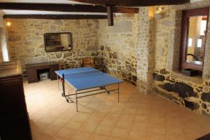 a ping pong table in a room with stone walls at Casa de José in Cabeceiras de Basto