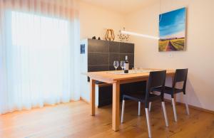 comedor con mesa de madera y sillas en Chalet Alpenrose 134qm am Golfplatz Oberstaufen, en Oberstaufen