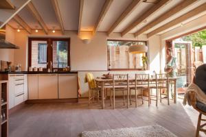 a kitchen and dining room with a table and chairs at Ecolodge de Parel Schoorl in Schoorl