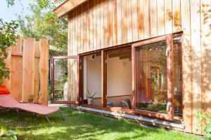 a glass house with a chair in the yard at Ecolodge de Parel Schoorl in Schoorl