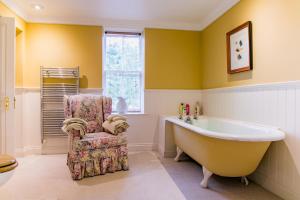 a bathroom with a large tub and a chair at Scatwell House in Garve +81 photos