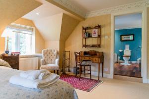 a bedroom with a bed and a desk and a chair at Scatwell House in Garve