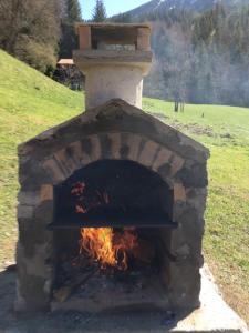 a brick oven with a fire inside of it at Chalet Fleur des Neiges in Saint-Jean-d'Aulps