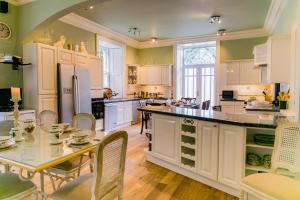 a kitchen with white cabinets and a table with chairs at Scatwell House in Garve