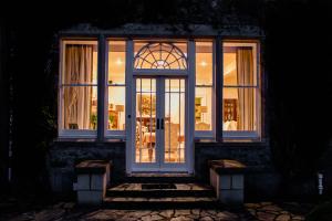 a door of a house with a window at night at Scatwell House in Garve