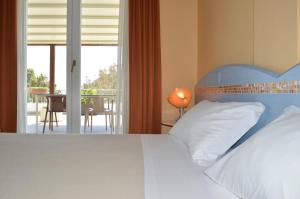 a bedroom with a bed and a balcony at Hotel Chentu Lunas in Cagliari