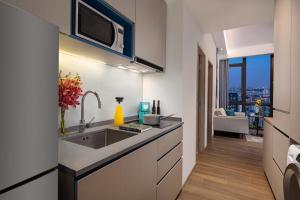 a kitchen with a sink and a microwave at Citadines Balestier in Singapore