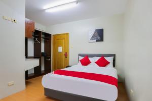a bedroom with a large bed with red pillows at OYO 190 Anglo Residences in Manila