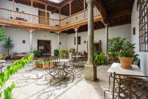 a courtyard with tables and chairs in a building at Palacio Conde de Cabra in Granada