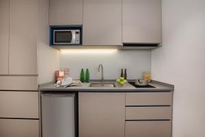 a kitchen with a sink and a microwave at Citadines Balestier in Singapore