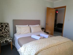但尼丁的住宿－美麗全景公寓，一张带两个枕头的床和一把椅子