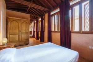 1 dormitorio con 1 cama y algunas ventanas en Palacio Conde de Cabra, en Granada