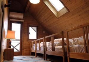 a bedroom with two bunk beds in a wooden cabin at Pension Kamifuji in Osaki +168 photos