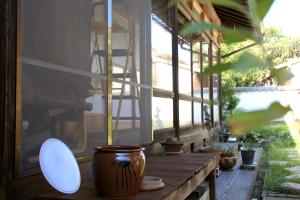 a porch with a table with a pot and a window at Koyado Namiji in Matsue +16 photos