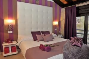 1 dormitorio con 1 cama blanca grande y paredes moradas en El Balcon Del Cañon, en Ucero