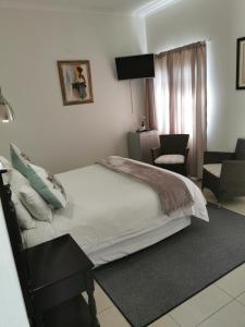 1 dormitorio con 1 cama, 1 silla y 1 ventana en Victoria and Alfred Guest House, en Port Elizabeth
