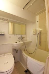 a bathroom with a toilet and a sink and a bath tub at Business Inn Sennichimae Hotel in Osaka