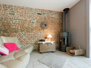 a living room with a couch and a brick wall at Magnificent character cottage with hot tub in Marche-en-Famenne