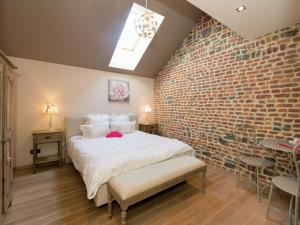 Un dormitorio con una pared de ladrillo y una cama en Magnificent character cottage with hot tub, en Marche-en-Famenne
