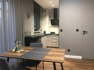 a kitchen with a wooden table in a room at Apartament SUNTIME in Radom +6 photos