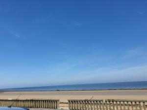a beach with a wooden fence and the ocean at Chambres d'Hotes Elvire et Laurent Barbey in Sainte-Marie-du-Mont