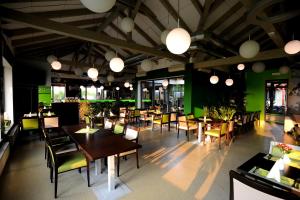 a restaurant with wooden tables and chairs and green walls at Black Bridge Hotel Apartment in Prague