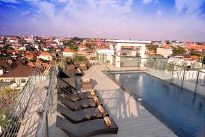 a balcony with a swimming pool and a city at Zia Hotel Kuta in Kuta