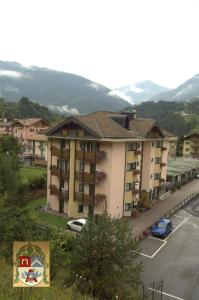 Blick auf ein Gebäude mit Parkplatz in der Unterkunft Residenza Artini in Comano Terme