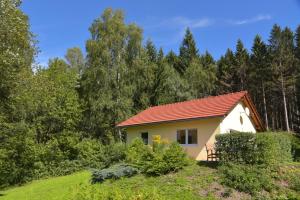 a small yellow house with a red roof at Bungalow am Waldesrand/ Haus Konrad in Suhl