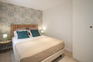 フンシャルにあるBAYLEAF Apartments - Casa D'Avóのベッドルーム(青い枕の大型ベッド1台付)