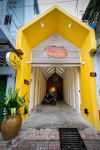 un bâtiment jaune et blanc avec une moto garée à l'intérieur dans l'établissement K2 Homestay & Coffee, à Cần Thơ