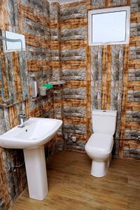 uma casa de banho com um lavatório branco e um WC. em WoodyCrest em Triquinimale