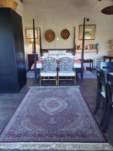 a living room with two chairs and a rug at Victorskloof Lodge in Hout Bay