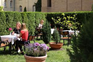 two women sitting at tables in a garden at Dom Muzyka in Gdańsk