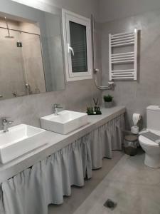 a bathroom with two sinks and a toilet at Athens Blossom House under Acropolis with private entrance in Athens
