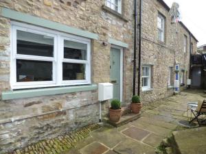 a brick building with a window and potted plants on it at No6 @ Globe Lane,Alston in Alston