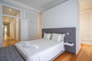 リスボンにあるAkicity Marques Rubyの白いベッドルーム(大型ベッド1台、グレーのヘッドボード付)