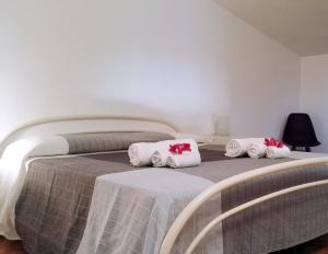 1 dormitorio con 1 cama con almohadas blancas y rojas en Villa San Lorenzo, en Reitani