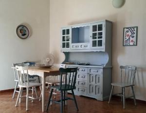 uma cozinha com uma mesa e um armário branco em Villa San Lorenzo em Reitani