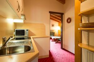 a kitchen with a sink and a microwave at Chalet Rüfikopf in Lech am Arlberg