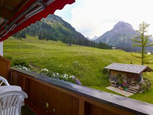 a balcony with a view of a field and mountains at Chalet Rüfikopf in Lech am Arlberg