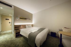 a hotel room with a bed and a desk at Shizutetsu Hotel Prezio Kyoto Shijo in Kyoto