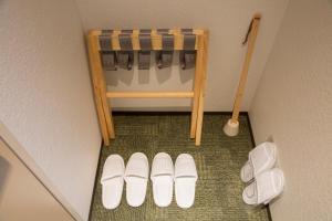 a pair of white shoes on the floor next to a crib at Shizutetsu Hotel Prezio Kyoto Shijo in Kyoto