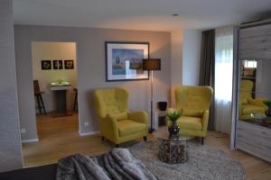 - un salon avec des chaises jaunes et une table dans l'établissement Waldstudio Comfort, à Simmerath