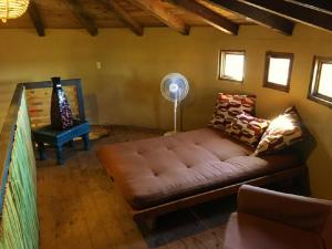 a living room with a brown couch and a fan at Casa Nativo - The Heart of the Vineyard in Valle de Guadalupe