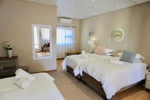 a bedroom with two beds and a mirror at Boutique Guesthouse Mariental in Mariental