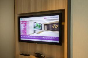 a flat screen tv hanging on a wall at Shizutetsu Hotel Prezio Kyoto Shijo in Kyoto